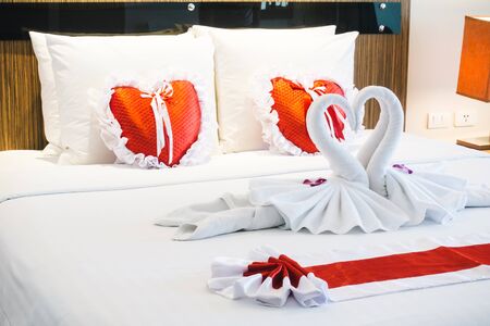 Romantic beautiful luxury bed decoration with heart pillow light lamp and rose flower in bedroom interior - Vintage Light Filterの写真素材