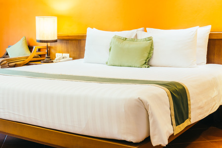 Beautiful luxury Pillow on bed with light lamp decoration in bedroom interior - Vintage Light Filterの写真素材
