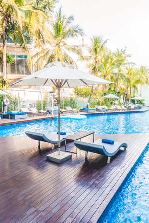 Umbrella pool and chair around beautiful luxury swimming pool in hotel resort - Vintage Light film Filterのeditorial素材