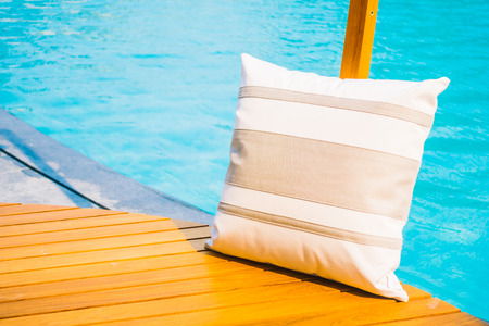 Selective focus point at pillow on deck around swimming pool in hotel resort - Vintage Light Filter