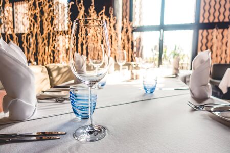 Selective focus point on wine glass with table setting for dinning in hotel restaurant - Vintage Light Filterの写真素材
