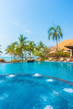 Beautiful luxury Swimming pool with palm tree and sea background in hotel pool resort - Boost up color Processingのeditorial素材