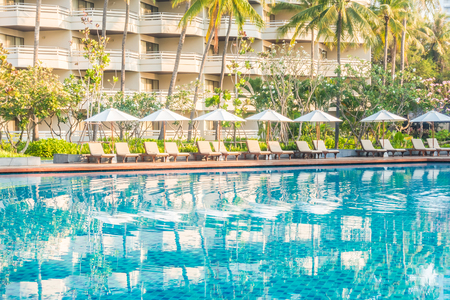 Beautiful luxury outdoor swimming pool with umbrella and chair in hotel pool resort - Vintage light Filterのeditorial素材