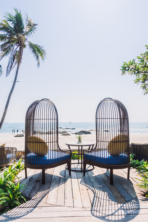 Outdoot patio with pillow on sofa and chair on the beach and sea - Vintage Light Filterの写真素材