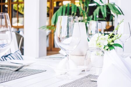 Selective focus point on table setting with wine glass , fork , knife , flower vase and other...