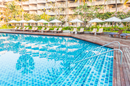 Beautiful luxury outdoor swimming pool with umbrella and chair in hotel pool resort - Vintage light Filterのeditorial素材