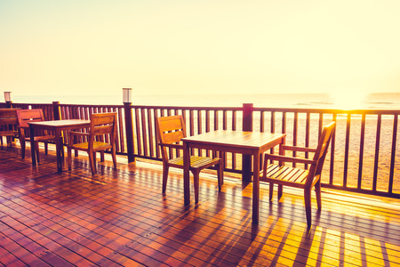 Outdoor empty chair and table on the beach decoration in restaurant - Vintage Filterの写真素材