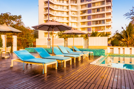 Beautiful luxury swimming pool in hotel resort with umbrella and chair in sunset times - Vintage Filter and Boost up color processingのeditorial素材