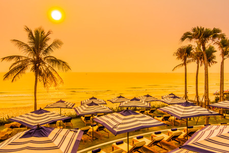 Beautiful luxury outdoor swimming pool in hotel resort with silhouette umbrella and chair and coconut palm tree - Vintage Filter and Boost up color Processingの写真素材