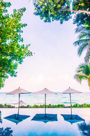 Beautiful luxury Umbrella pool and chair around swimming pool neary beach and sea in hotel resort - Vintage Filterのeditorial素材