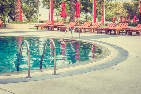 Beautiful luxury outdoor swimming pool with umbrella and chair in hotel pool resort - Vintage Filterのeditorial素材
