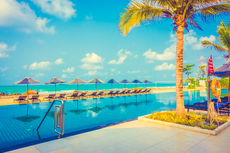 Beautiful luxury umbrella and chair around outdoor swimming pool in hotel resort neary sea and beach - Vintage Filterのeditorial素材