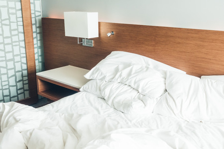 Messy white pillow on bed with light lamp decoration - Vintage light Filterの写真素材