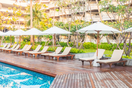Beautiful luxury outdoor swimming pool with umbrella and chair in hotel pool resort - Vintage light Filterのeditorial素材