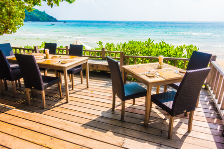 Empty table and chair decoration outdoor restaurant with sea and beach backgroundのeditorial素材