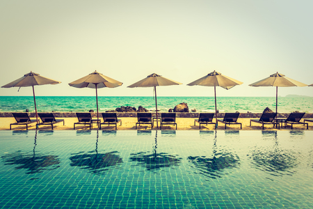 Beautiful luxury umbrella and chair around outdoor swimming pool in hotel resort neary sea and beach - Vintage Filterのeditorial素材