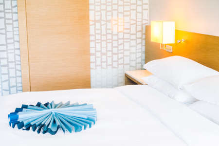 Beautiful luxury and comfort white pillow on bed with light lamp on wall decoration in bedroom interior - Vintage light Filterの写真素材