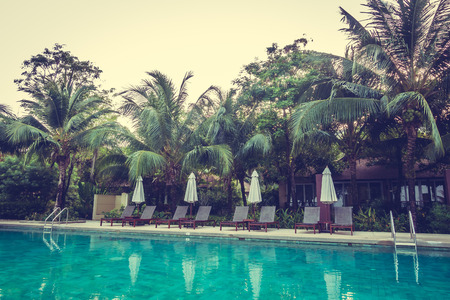 Beautiful luxury outdoor swimming pool with umbrella and chair around pool in hotel resort - Vintage Filterのeditorial素材