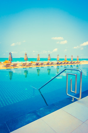 Beautiful luxury umbrella and chair around outdoor swimming pool in hotel resort neary sea and beach - Vintage Filterのeditorial素材