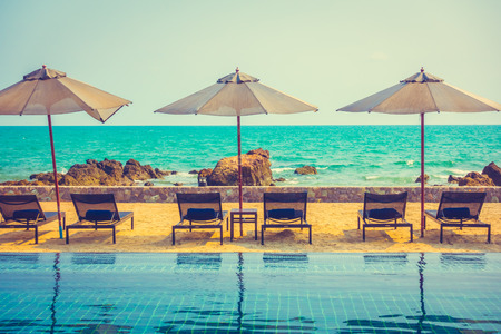 Beautiful luxury umbrella and chair around outdoor swimming pool in hotel resort neary sea and beach - Vintage Filterのeditorial素材
