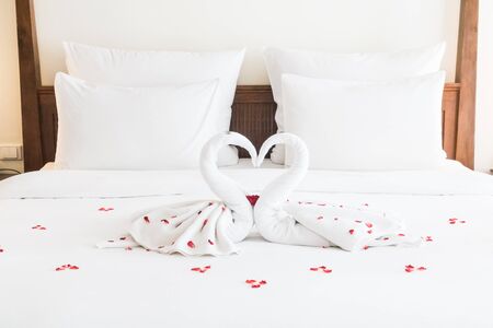 Swan towel decoration on bed with white pillow in bedroom interiorの写真素材