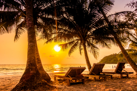 Beautiful tropical ocean or sea and sand beach on island with silhouette coconut palm tree and empty chair on Sunset times - Vintage Filterの写真素材