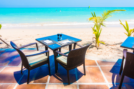 Empty table and chair on the tropical beach and sea - boost up color Processingの写真素材
