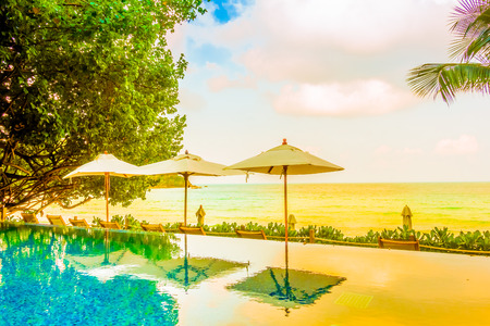 Beautiful luxury Umbrella pool and chair around swimming pool neary beach and sea in hotel resort - Vintage Filterのeditorial素材
