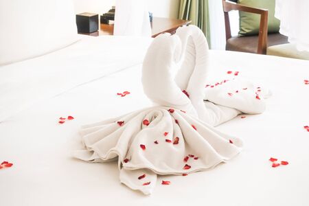 Swan towel decoration on bed with white pillow in bedroom interiorの写真素材