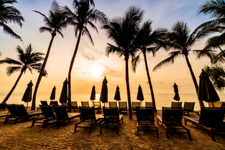 Beautiful coconut palm tree on the beach and sea with umbrella and chair on sunrise time - Vintage Filterの写真素材