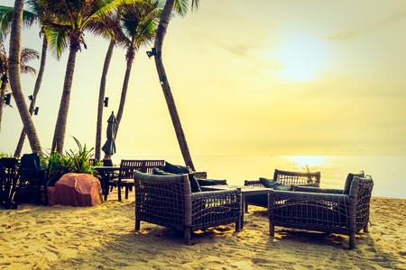 Beautiful coconut palm tree on the beach and sea with umbrella and chair on sunrise time - Vintage Filterの写真素材