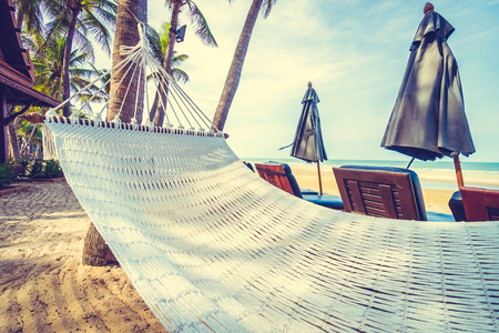 Empty hammock on the tropical beach and sea with umbrella and chair - Vintage Filterの写真素材