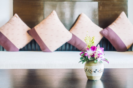 Selective focus point on vase flower decoration in living room area with pillow on sofa - Vintage light Filterの写真素材