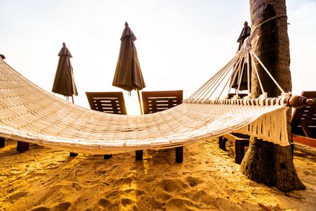 Empty hammock on the beach and sea with coconut palm tree at sunrise time - Vintage Filterの写真素材