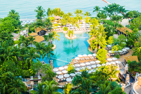 Aerial view of Umbrella and chair around luxury swimming pool landscape with palm tree in hotel resort - Boost up color Processingのeditorial素材