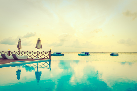 Beautiful luxury outdoor swimming pool with umbrella and chair in hotel resort at maldives - Boost up color and Filter effect Processingのeditorial素材