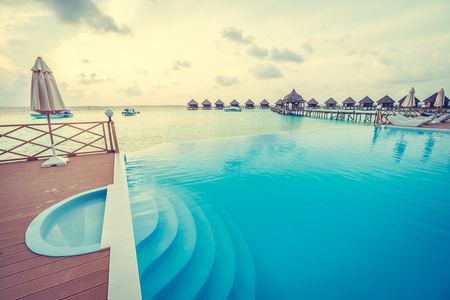 Beautiful luxury outdoor swimming pool with umbrella and chair in hotel resort at maldives - Boost up color and Filter effect Processingのeditorial素材