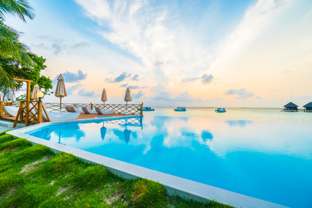 Beautiful luxury outdoor swimming pool with umbrella and chair in hotel resort at maldives - Boost up color and Filter effect Processingのeditorial素材