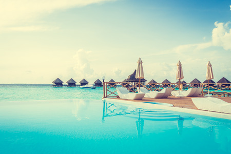 Beautiful luxury outdoor swimming pool with umbrella and chair in hotel resort at maldives - Boost up color and Filter effect Processingのeditorial素材