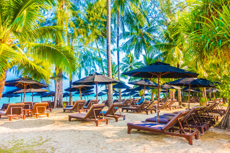 Umbrella and chair on the beautiful tropical beach and sea landscape with coconut palm tree - Boost up color Processingの写真素材