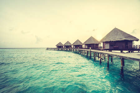 Beautiful tropical Sunset over maldives island with water bungalow in hotel resort - Vintage Filter and Boost up color Processingのeditorial素材