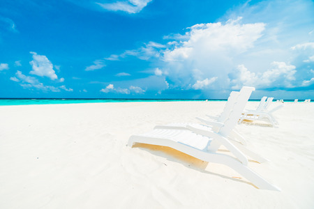 Umbrella and chair on the beautiful tropical beach and sea around hotel resort in maldives island -...