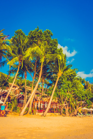 Beautiful tropical beach and sea landscape with coconut palm tree and umbrella and chair - Vintage Filter and Boost up color Processingのeditorial素材