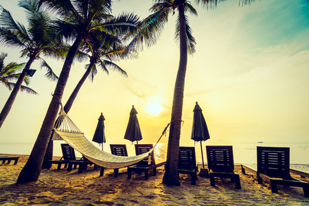 Empty hammock on the beach and sea with coconut palm tree at sunrise time - Vintage Filterの写真素材