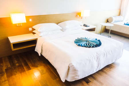 Beautiful luxury and comfort white pillow on bed with light lamp on wall decoration in bedroom interior - Vintage light Filterのeditorial素材