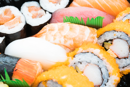 Close up and Selective focus point on Seafood sushi japanese food style with California roll maki , Salmon Sushi , Tuna Sushi , Shrimp Sushi , Squid sushi , Sweet egg sushi and Etc in black boxの写真素材