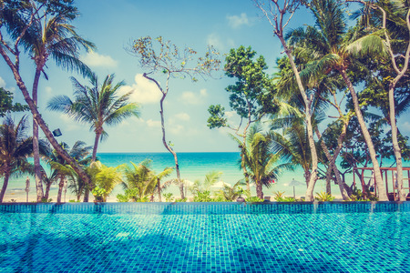 Beautiful luxury Umbrella pool and chair around swimming pool neary beach and sea in hotel resort -...