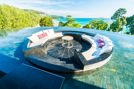 Beautiful luxury outdoor patio decoration with sofa and pillow on sea and ocean with blue sky backgroundの写真素材