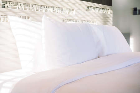 Beautiful white pillow on bed decoration in bedroom interior - Vintage light Filterの写真素材