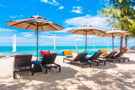Outdoor with umbrella and chair on beautiful tropical beach and sea and blue sky background